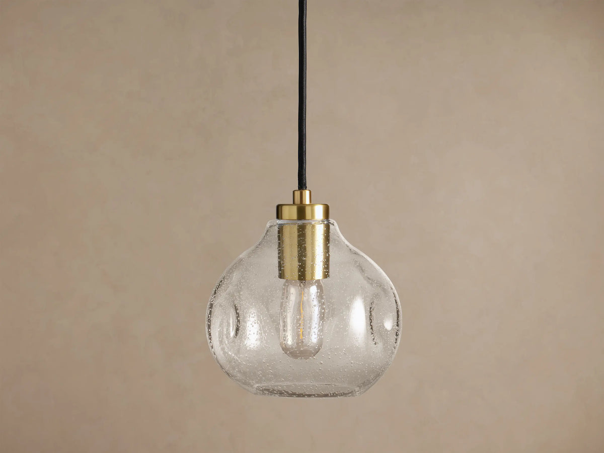 Organic 8" Pendant: Clear, seeded mouth-blown glass shade with brass hardware, black cord, and a glowing Edison bulb.
