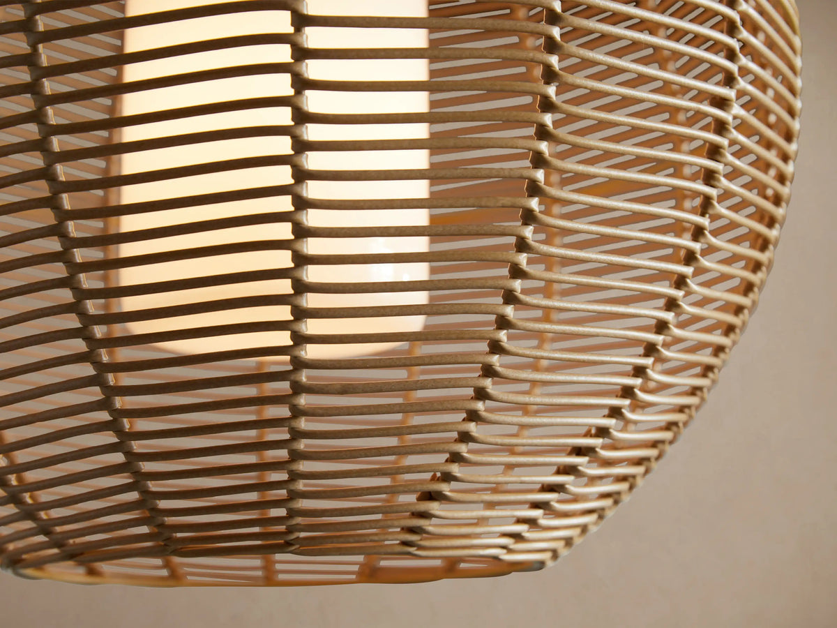 Cohen Globe Outdoor Pendant. Woven natural wicker globe light fixture hanging from a black pole, with a white internal glass shade.
