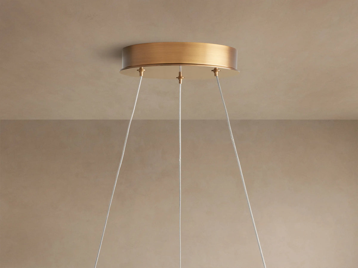 Close-up of Lyla Chandelier with hand-blown white glass petals and glowing integrated LEDs on a plated brass frame.