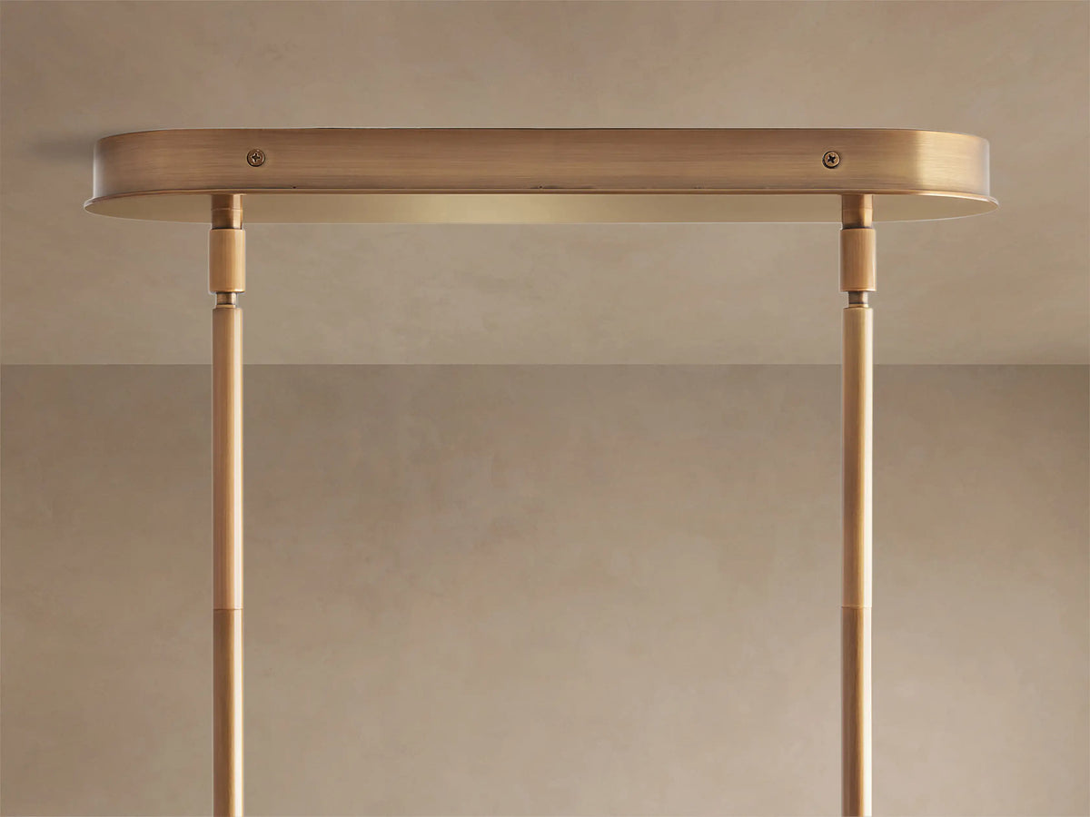 Close-up of Lyla Linear Chandelier with milky white, irregularly shaped hand-blown glass shades on a plated brass frame.