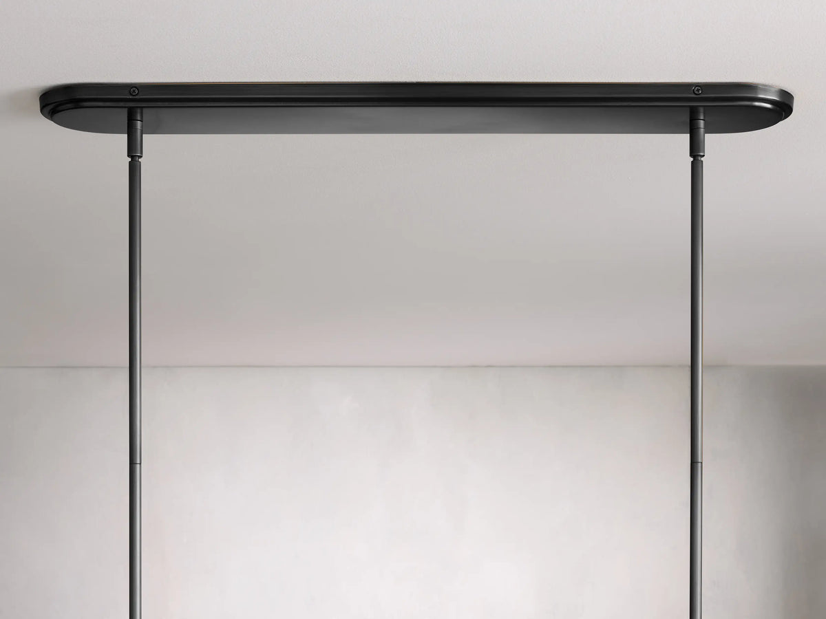 Rhodes Linear Chandelier features black metal rods with intricate detailing and white tapered linen shades against a neutral background.