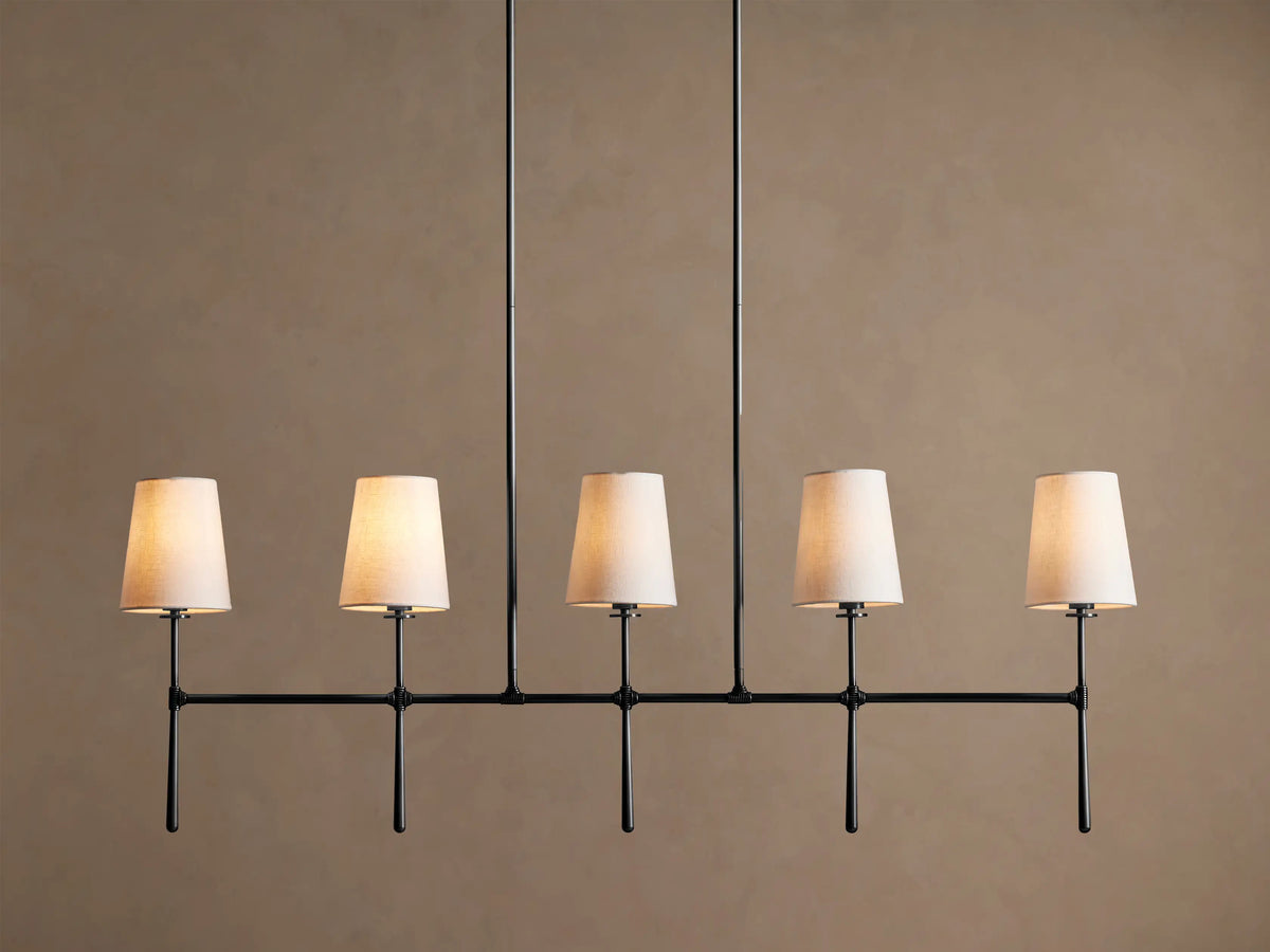 Rhodes Linear Chandelier with 5 tapered light linen shades on a dark metal horizontal bar, hanging from two rods.