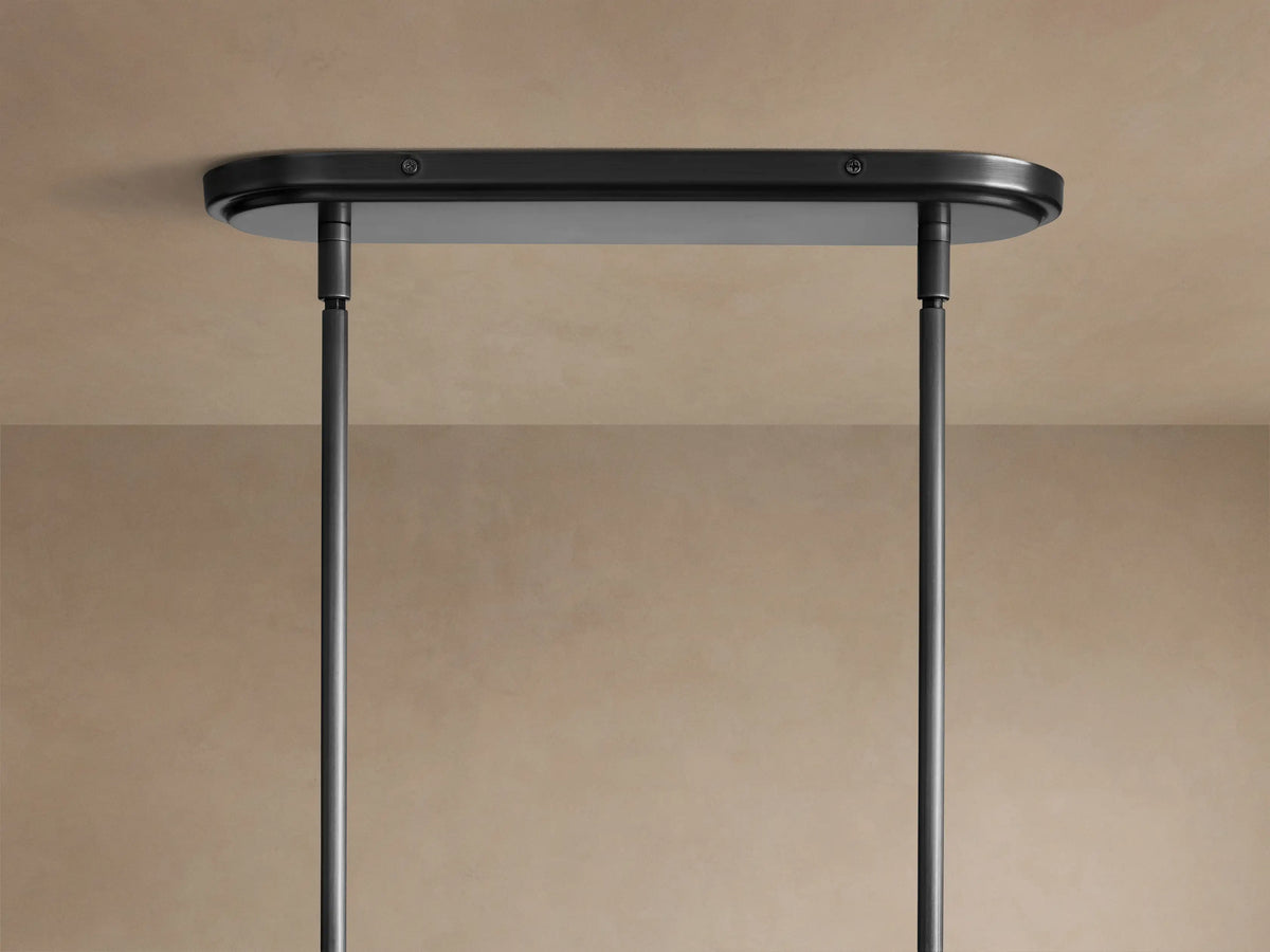 Close-up of Rhodes Linear Chandelier: two white tapered linen shades & dark metal rods with decorative ribbed joints.