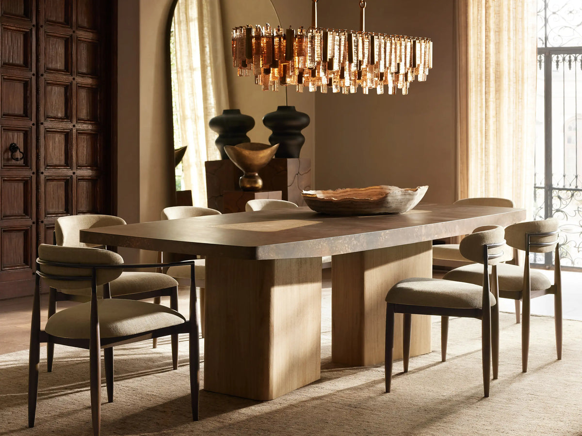 Neve Linear Chandelier, a rectangular fixture with glowing bronze cast glass rods and brass accents, suspended by chains.