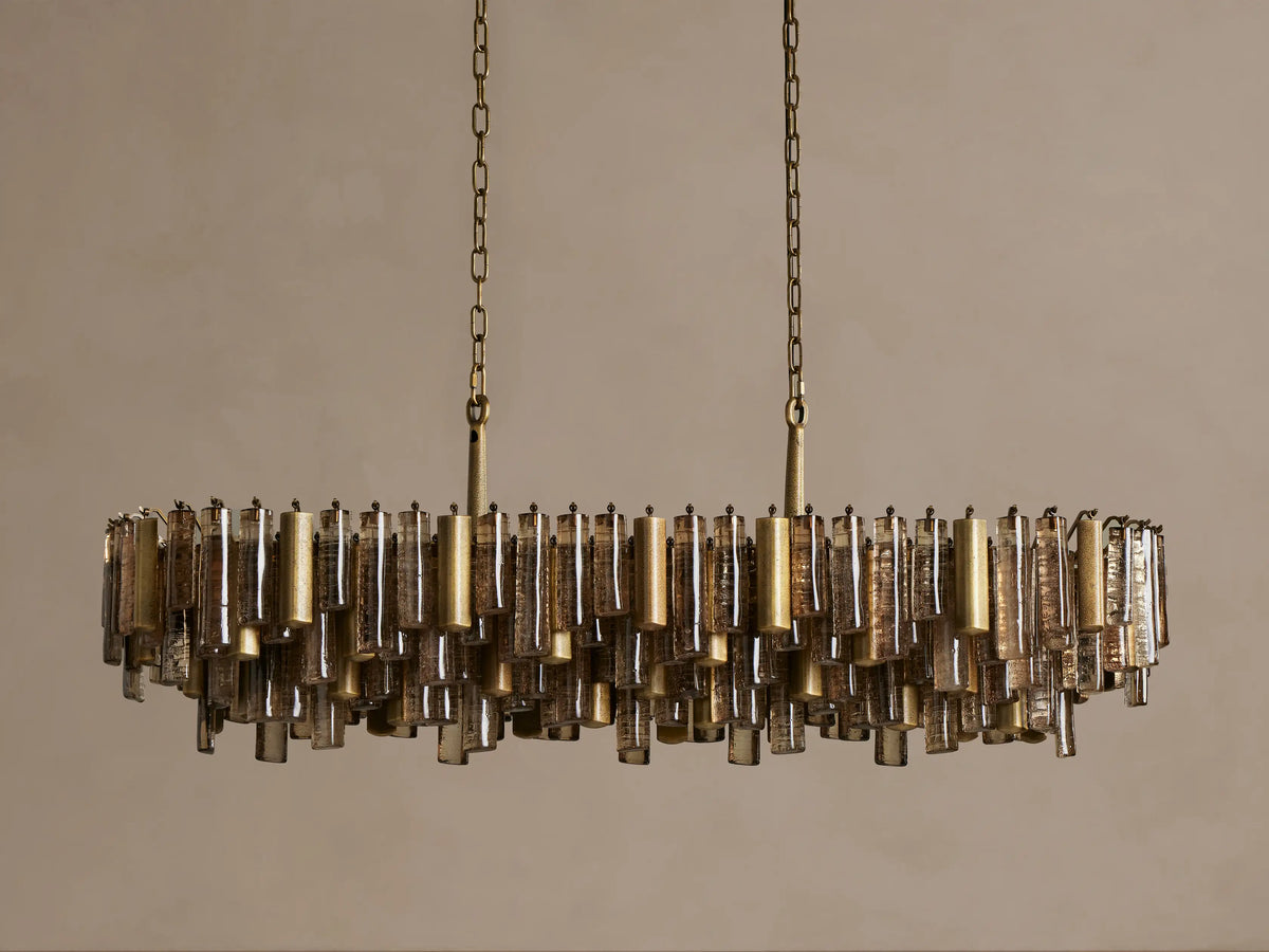 Neve Linear Chandelier with horizontal rows of brass-finished aluminum and textured bronze cast glass cylinders, suspended by chains.