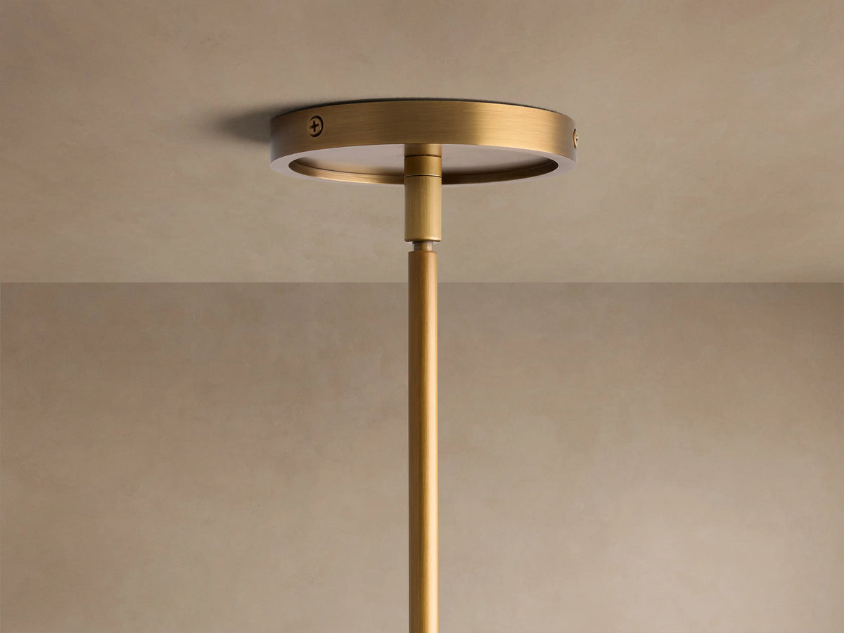 Close-up of Rhodes Chandelier in burnished brass, showing multiple arms with tapered off-white linen shades.