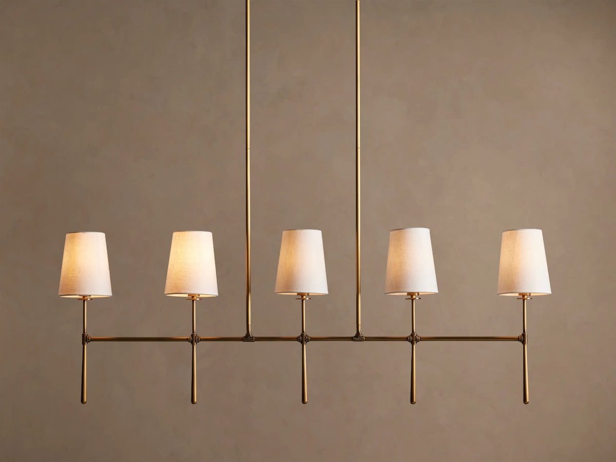 Rhodes Linear Chandelier, burnished brass finish, 5 lights with tapered off-white linen shades.