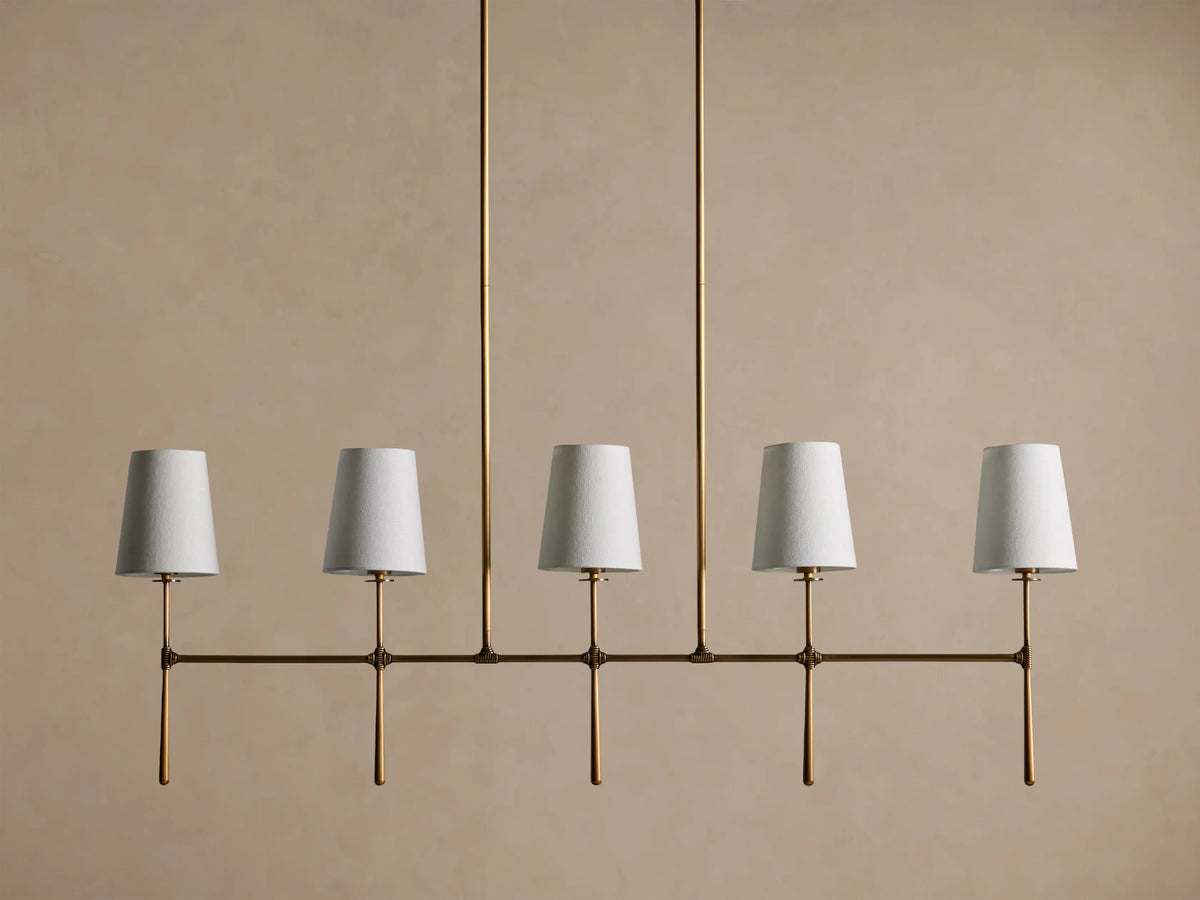 Rhodes Linear Chandelier, burnished brass finish, 5 lights with tapered off-white linen shades.