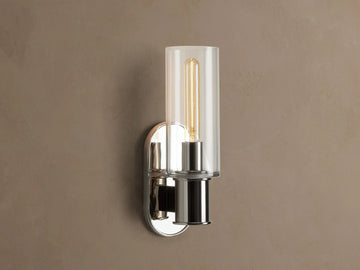 Harlin Sconce with polished nickel finish and clear glass cloche, mounted vertically on a wall, showing an Edison bulb.