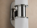 Harlin Double Sconce, vertically mounted, features two white milk glass cylinders and polished nickel accents on a beige wall.