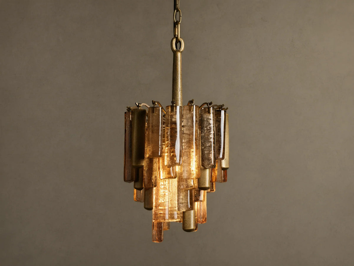 Neve Pendant, hanging, featuring a brass frame with tiered bronze cast glass panels, emitting a warm, inviting glow.