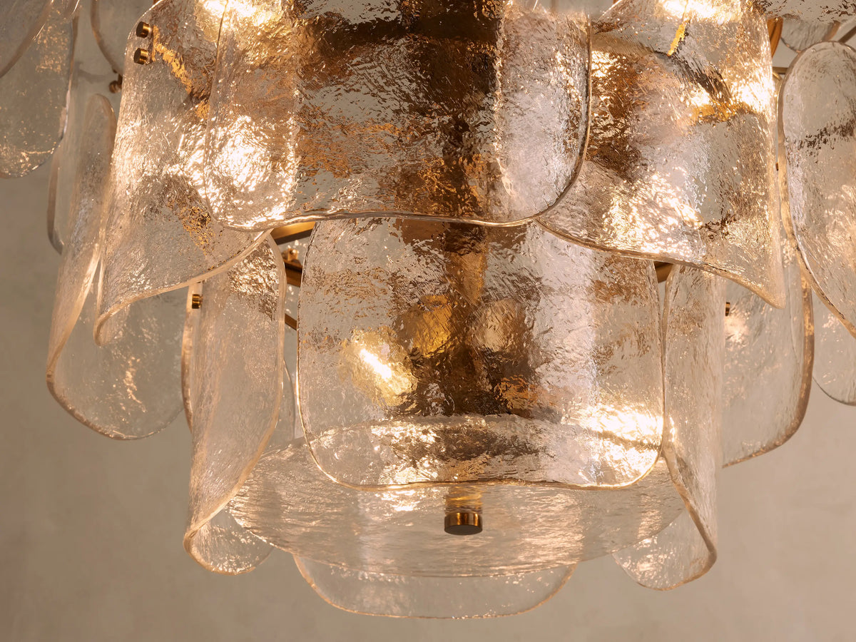 Blaire Round Chandelier with curved clear glass panels and brass-finished steel chain. Panels create a layered, artistic look.