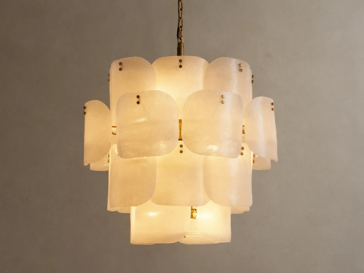 Blaire Round Chandelier. Multi-tiered, round chandelier with textured, pearlescent white molten glass panels glowing softly. Brass chain.