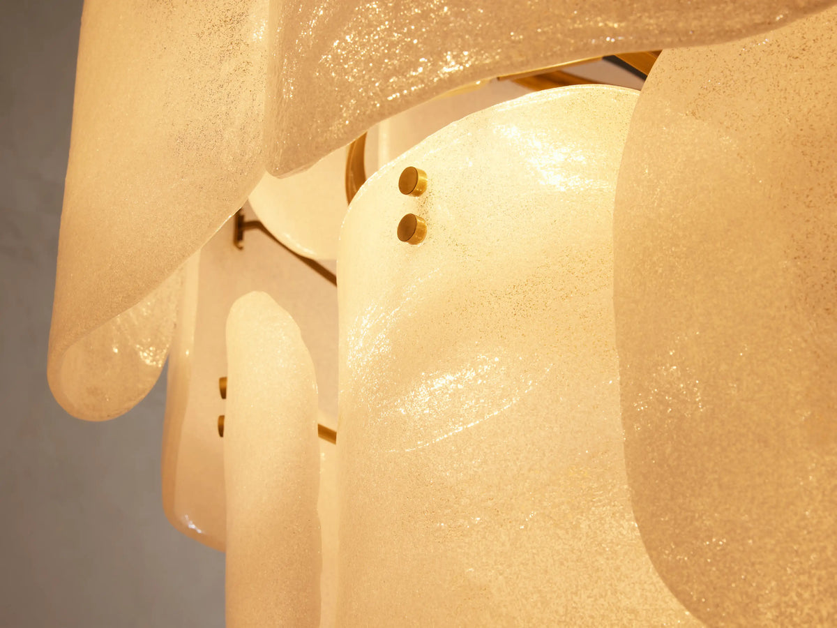 Close-up of Blaire Round Chandelier's glowing, curved, pearlescent white molten glass panels with textured, bubbled surface.