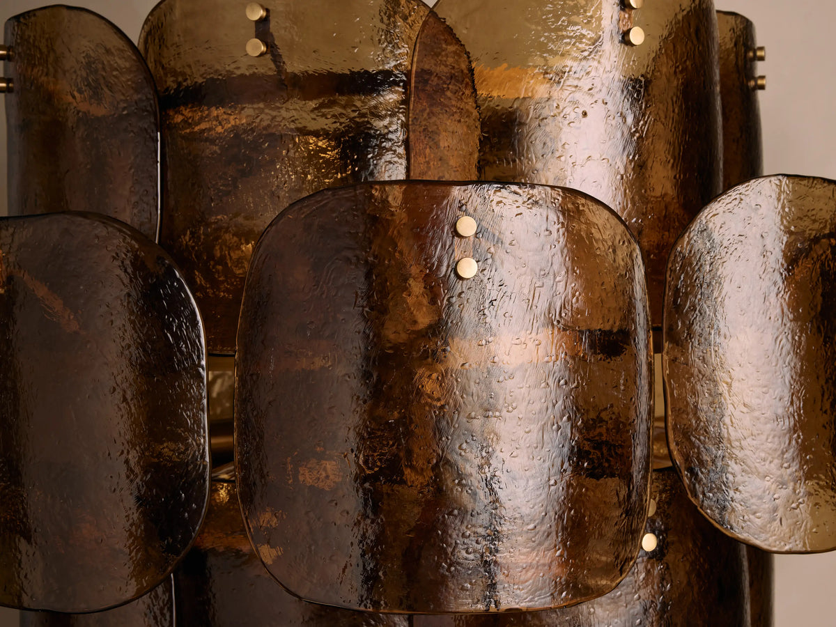 Close-up of the Blaire Round Chandelier featuring textured molten glass panels in a pearlescent finish, secured with brass bolts.