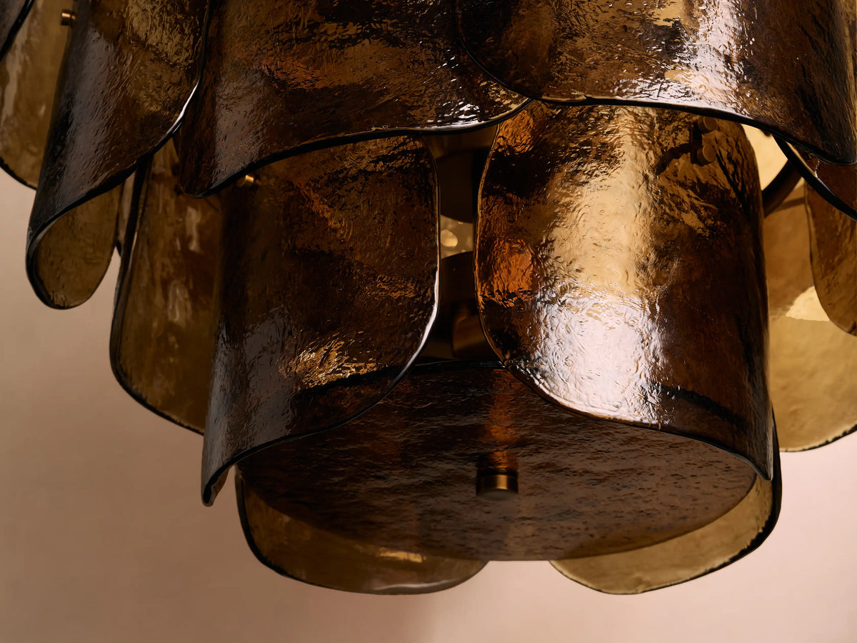 Blaire Round Chandelier with overlapping curved molten glass panels in a warm amber hue, creating a textured, flowing design.