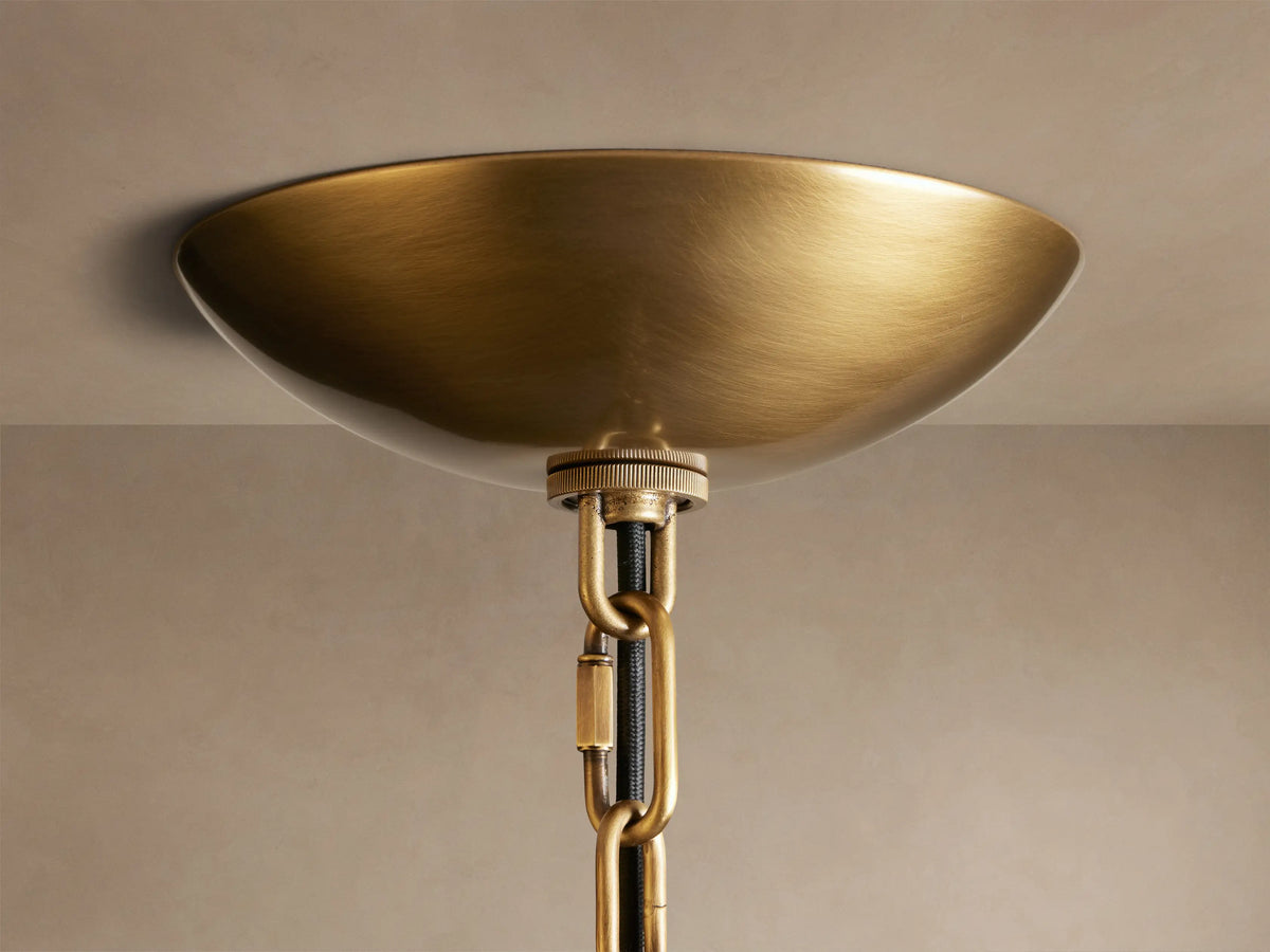 Blaire Round Chandelier's brass-finished steel chain connects to a ceiling mount, showing a close-up of the detailed brass texture.