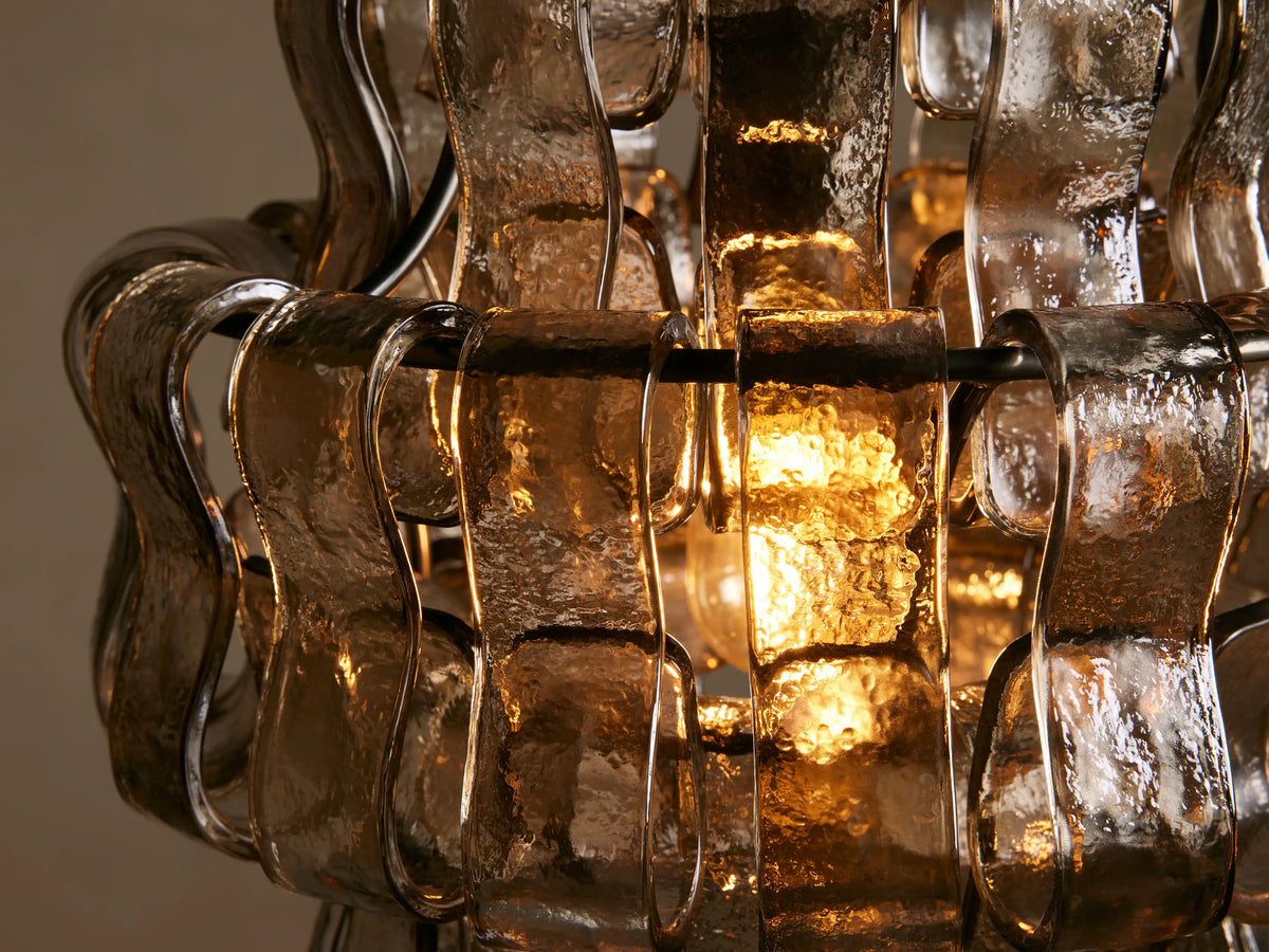 Ghiaccio Pendant hanging elegantly, crafted from curved glass and steel, featuring a textured, wavy design on a neutral background.