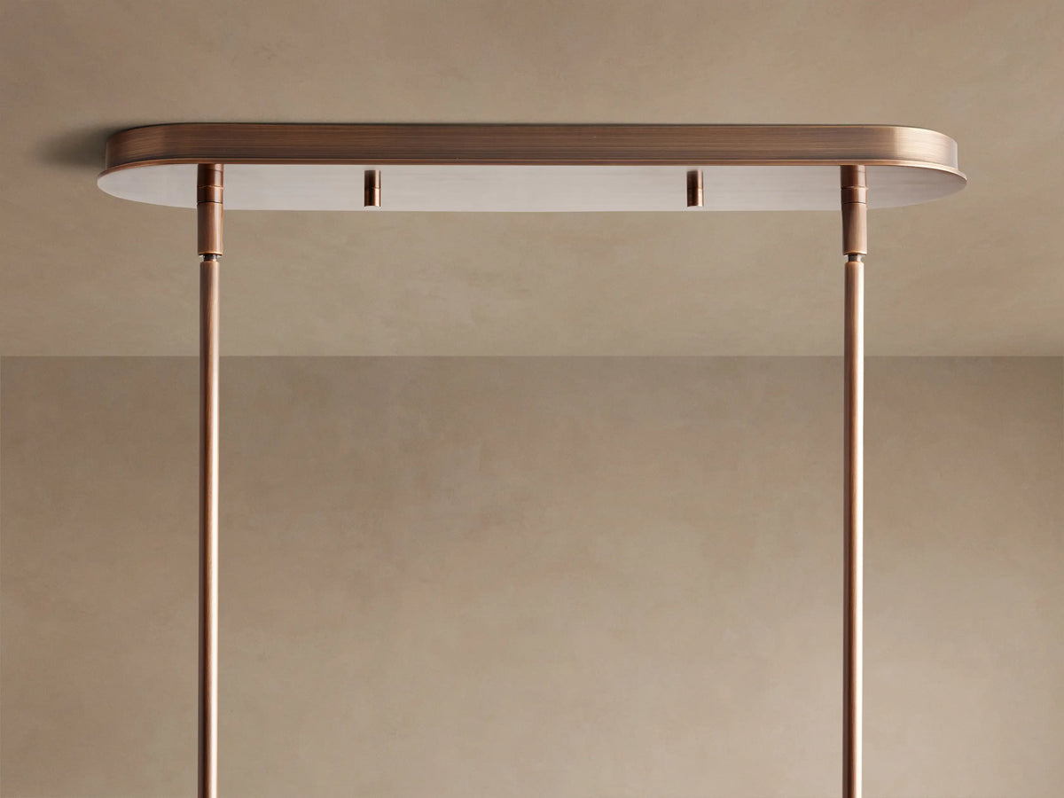 Close-up of Daphne Fabric Linear Chandelier with three cylindrical cream parchment shades, dark brown trim, and bronze linear frame, viewed from below.