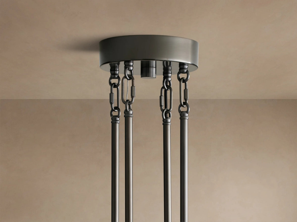 Close-up of Delsie Round Chandelier showing clear fluted glass panels and dark metal frame reflecting warm light.