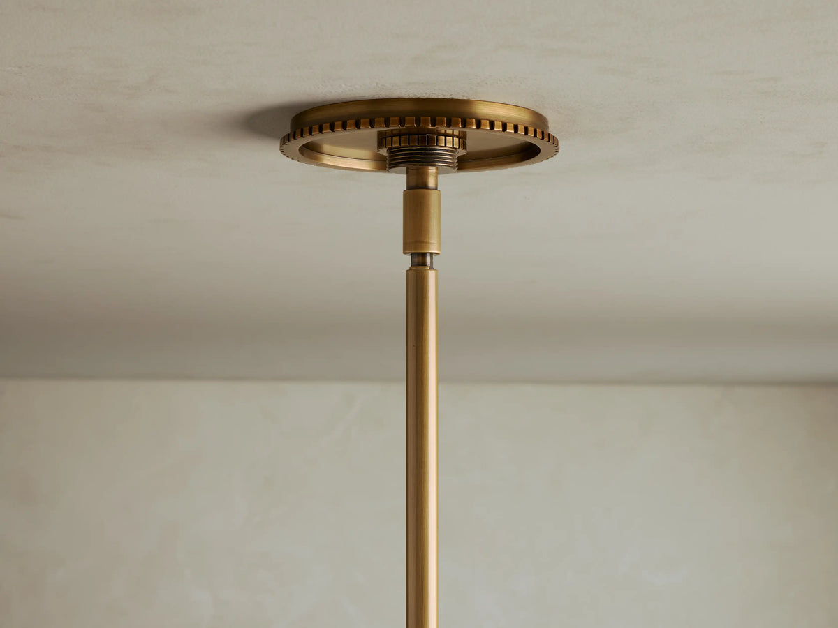 Close-up view of a brass lighting fixture with clear spherical glass shades and exposed filament bulbs.