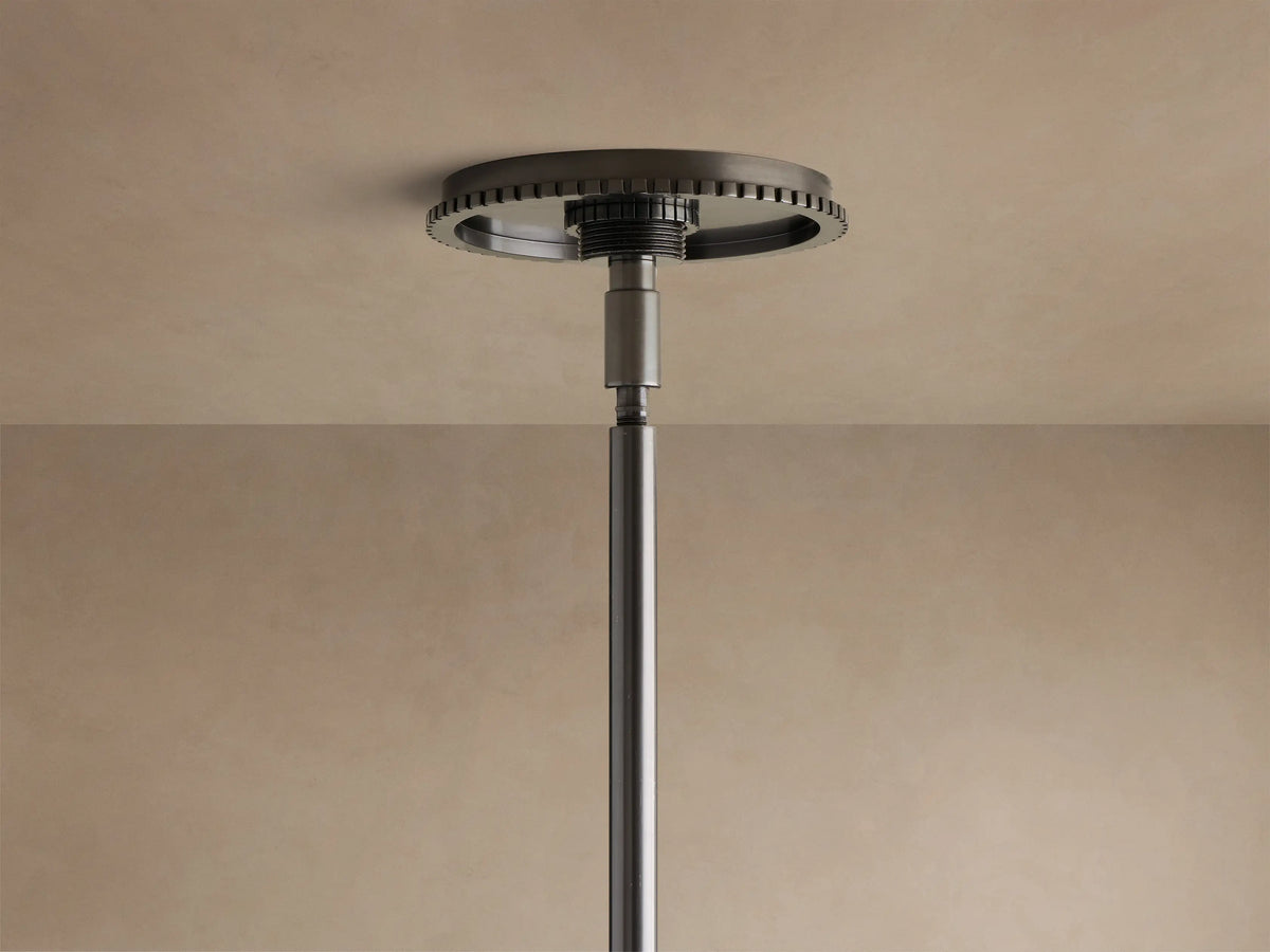Front view of a black linear chandelier with three illuminated clear glass globe shades, suspended from a straight rod.