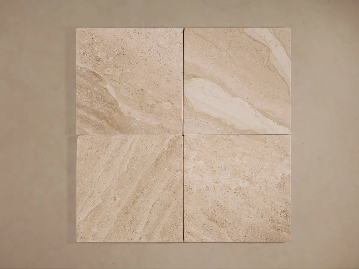 Four light beige square natural stone tiles with subtle veining, showcasing material for the Christie Floor Lamp's base.