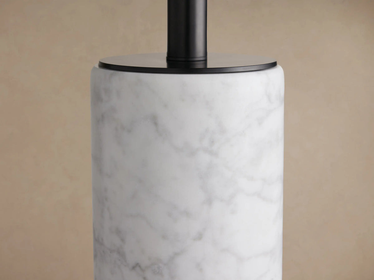 Brixton Table Lamp: cylindrical white marble base, black metal stem, and light beige fabric drum shade on a wooden table.