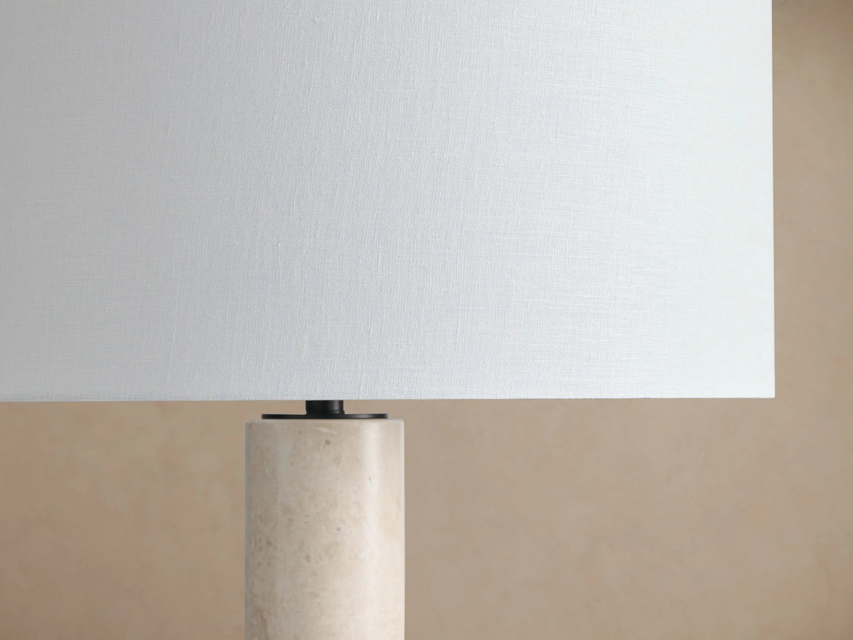 Brixton Floor Lamp with a light-colored marble cylindrical stem, a black circular base, and a white fabric drum shade.