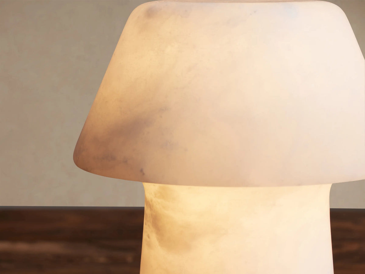 Daine Alabaster Outdoor Rechargeable Table Lamp, mushroom-shaped, white alabaster with subtle texture, on a wood table.