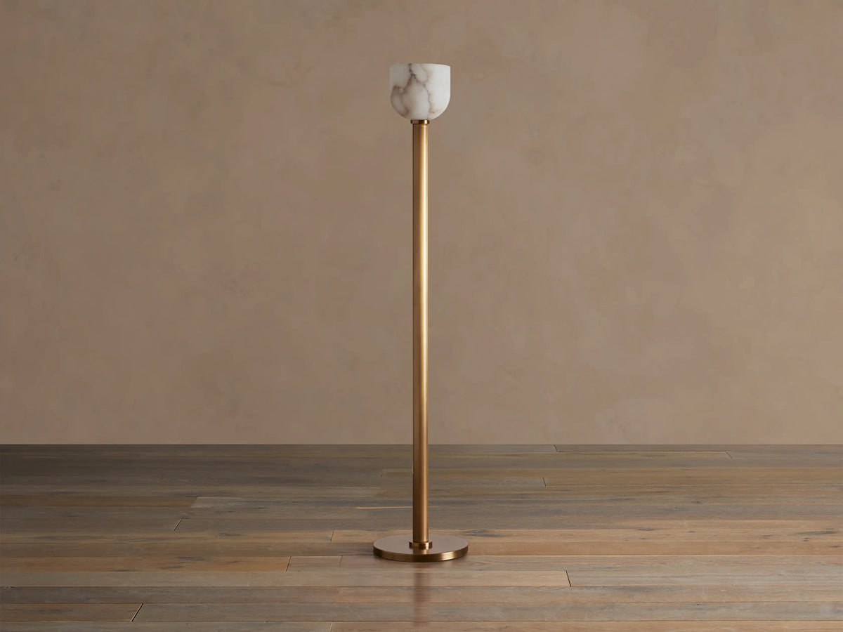 Illuminated Ansley Floor Lamp with a slender, antique brass stem & base, topped by a glowing, veined alabaster bowl shade.