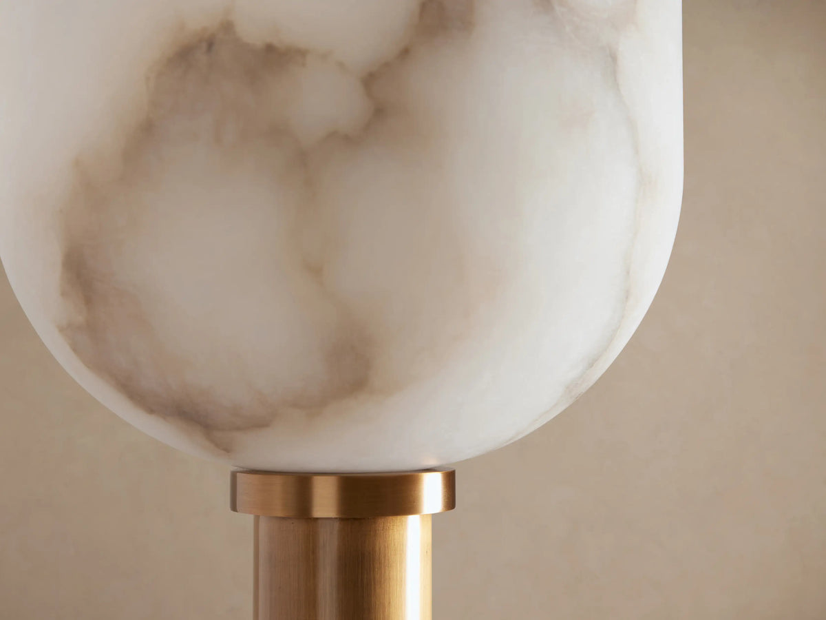 Ansley Floor Lamp, slender brass-toned steel, round base, and cup-shaped white marbled alabaster shade on wood floor.
