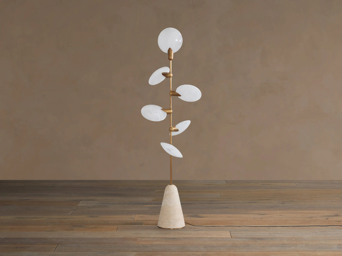 Lyla Floor Lamp: conical travertine base, golden stem with six glowing leaf-shaped white glass diffusers spirally.