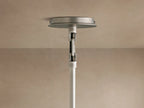 Close-up of a Linden Pendant, viewed from below, showing its light linen shade, warm interior glow, and dark metal accent.