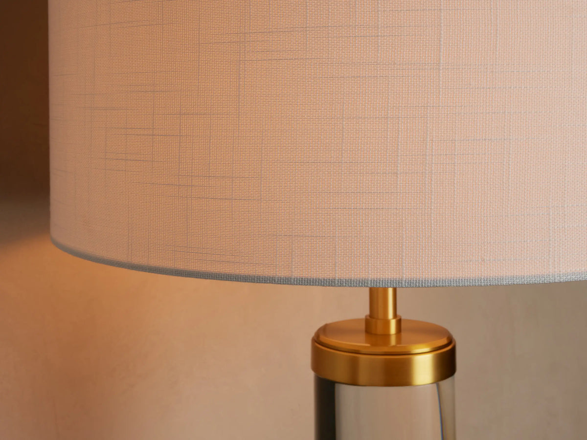 Close-up of the Linden Crystal Table Lamp, highlighting its natural linen shade, brass-finished metal, and clear crystal column.