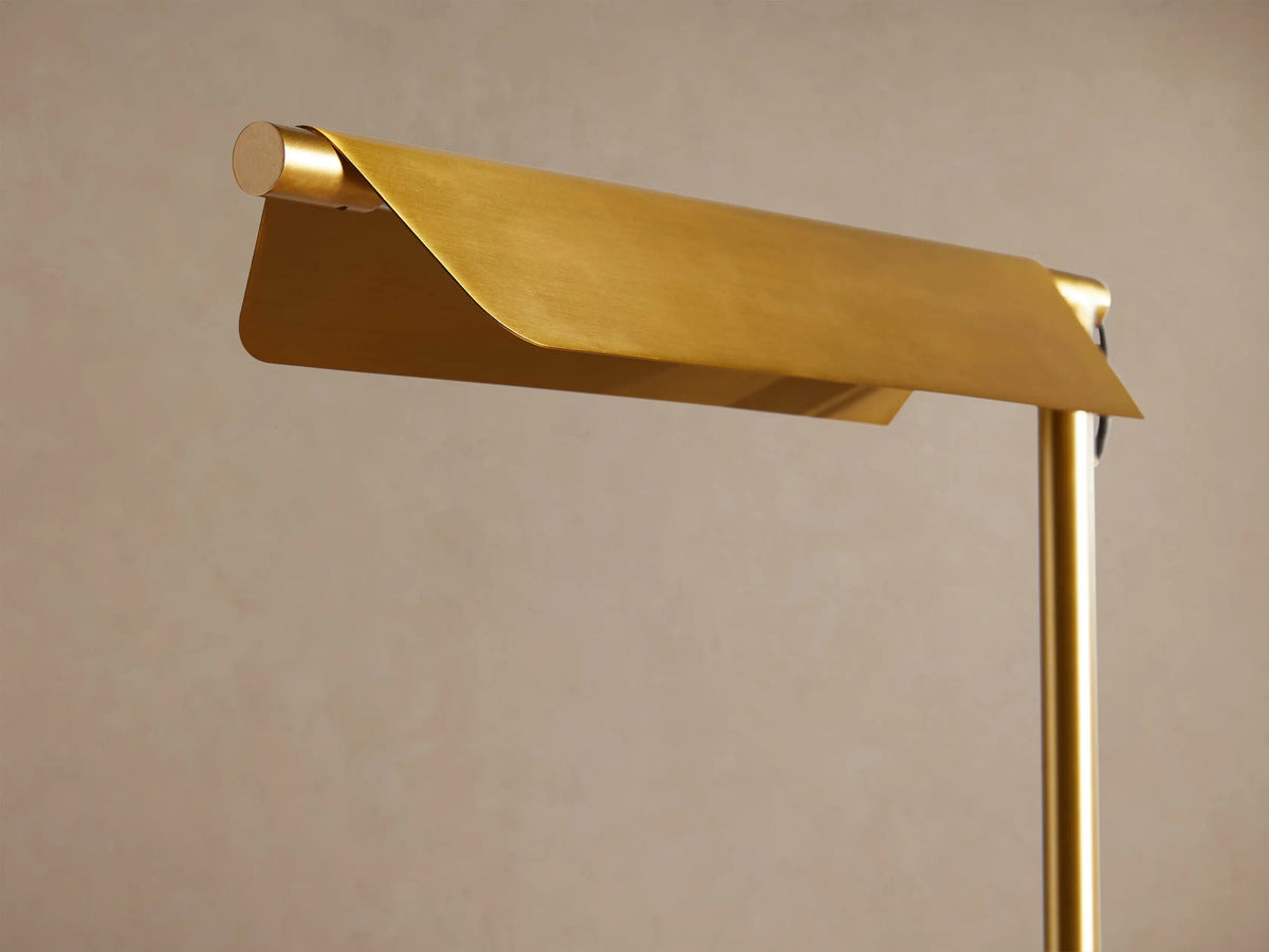 Axle Brass Task Table Lamp with rectangular shade, slim brass stand, and light grey base on wooden surface.