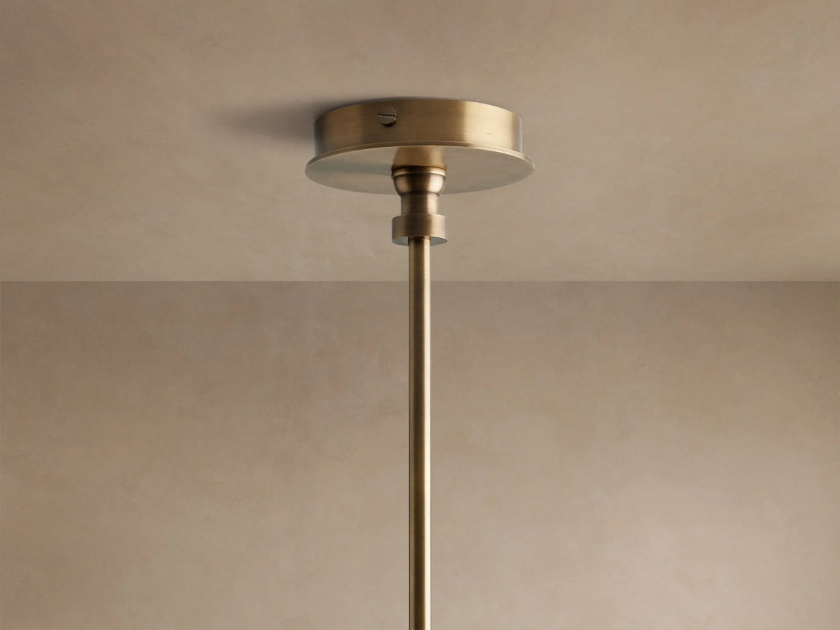 Close-up of Hastings Round Chandelier, showing tan leather frame with white stitching, antiqued brass rods, and white tapered linen shades.