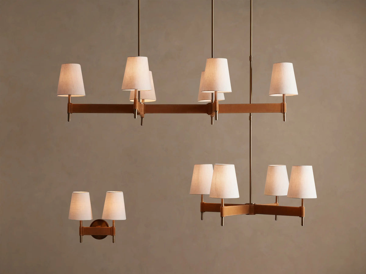 Close-up of Hastings Linear Chandelier's oblong antique brass canopy attached to a beige ceiling, with two vertical brass rods extending down.