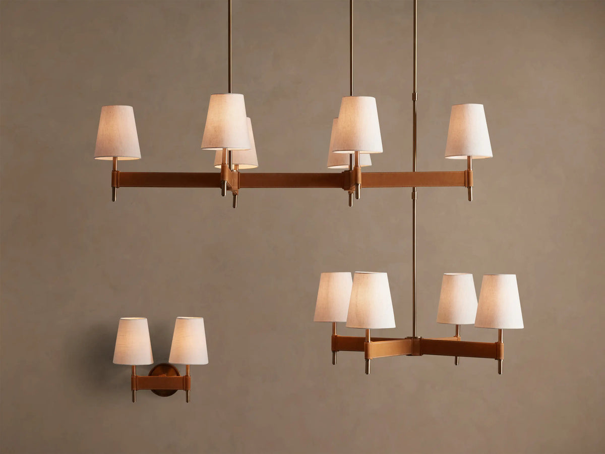 Close-up of a Hastings Round Chandelier's antiqued brass ceiling mount and suspension rod on a light ceiling.