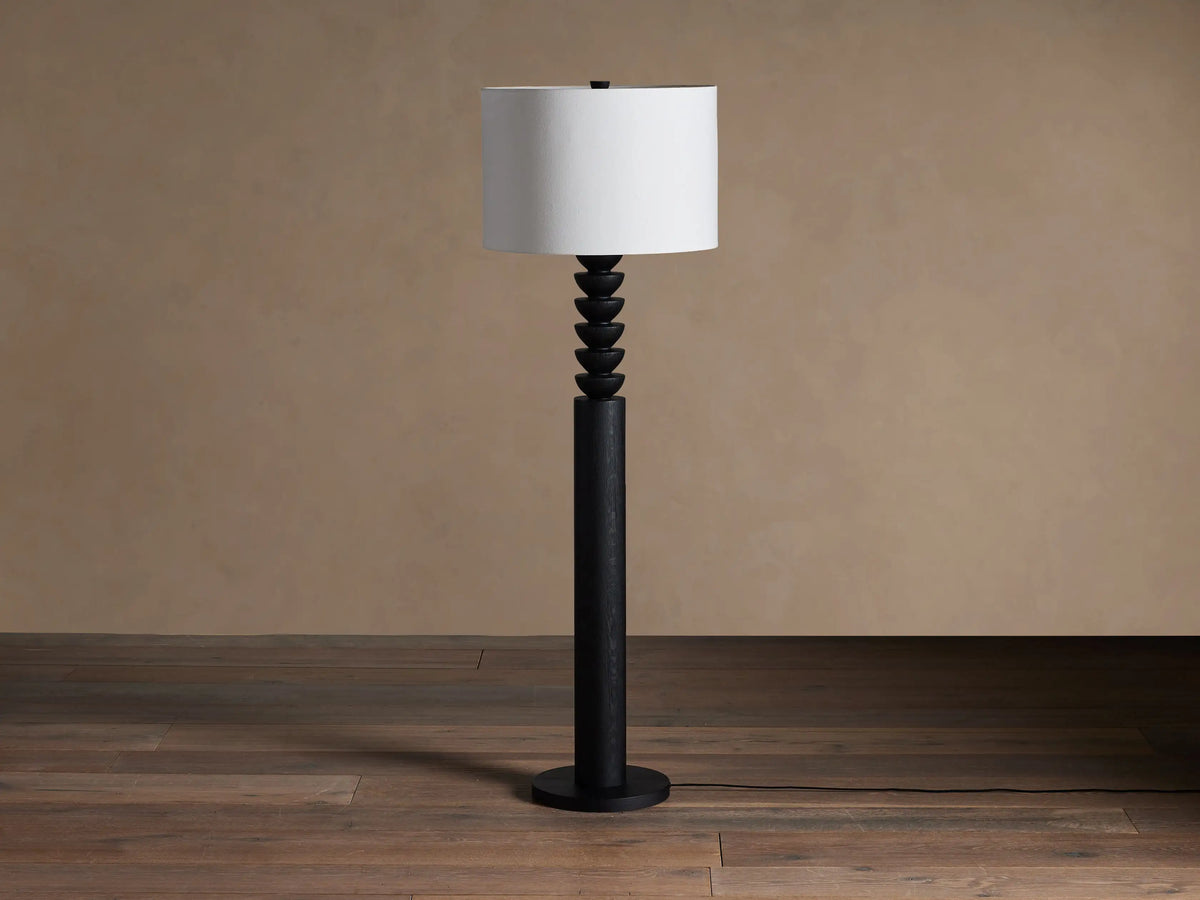 Black Lathe Floor Lamp with a cylindrical black oak base, stacked carved black wood details, and an off-white linen drum shade.