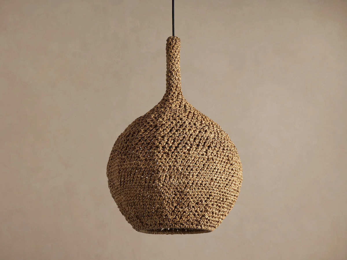 Canela 15" Pendant: Bell-shaped, natural tan handwoven banana rope fixture, glowing warmly, suspended.