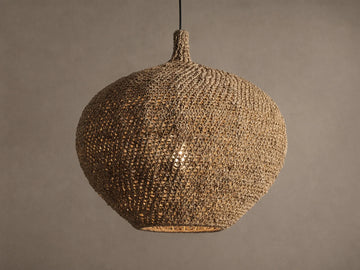 Canela 26" Pendant: round, handwoven natural banana rope light fixture hanging, with a warm glow from inside.