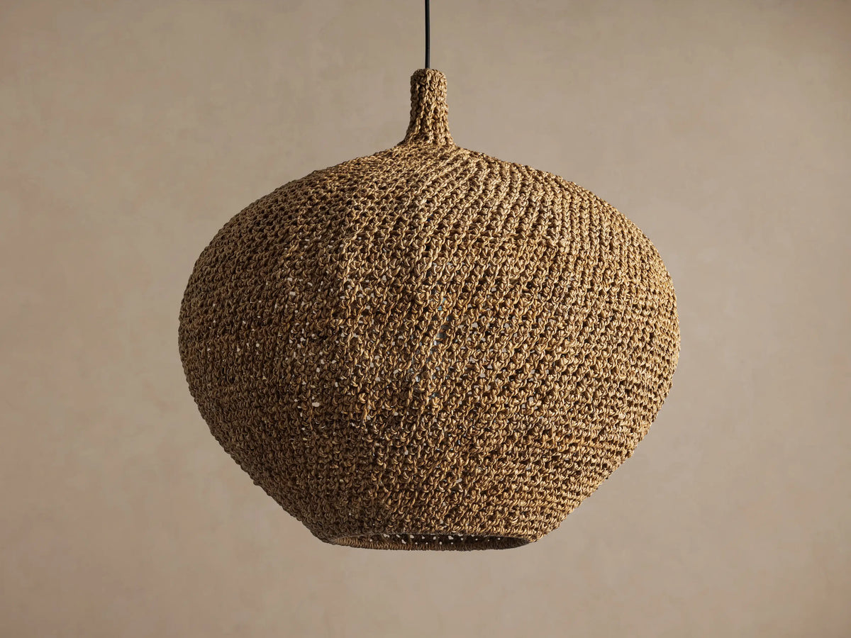 Canela 26" Pendant: round, handwoven natural banana rope light fixture hanging, with a warm glow from inside.