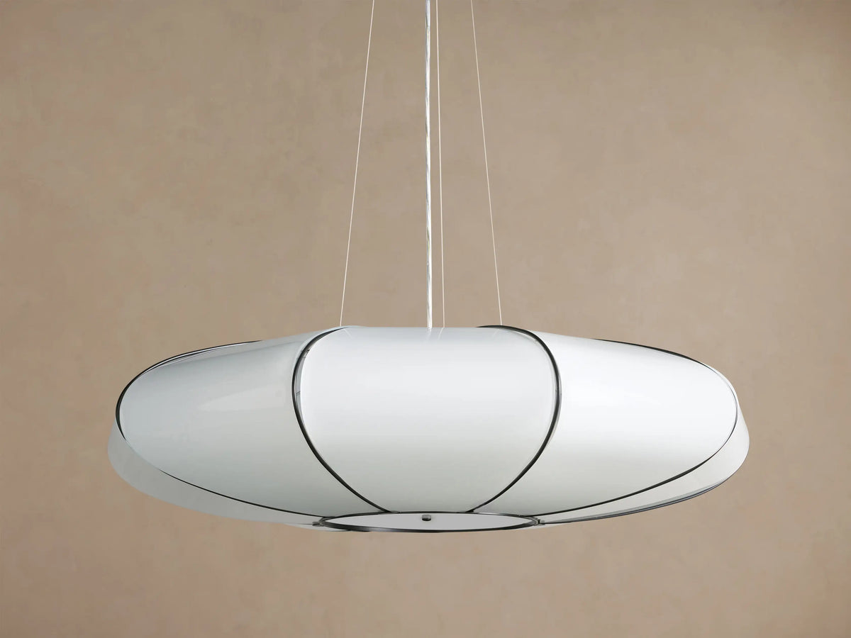 Nuvola Chandelier: elongated white milk glass oval pendant, bronze frame, softly glowing, hanging against a brown background.