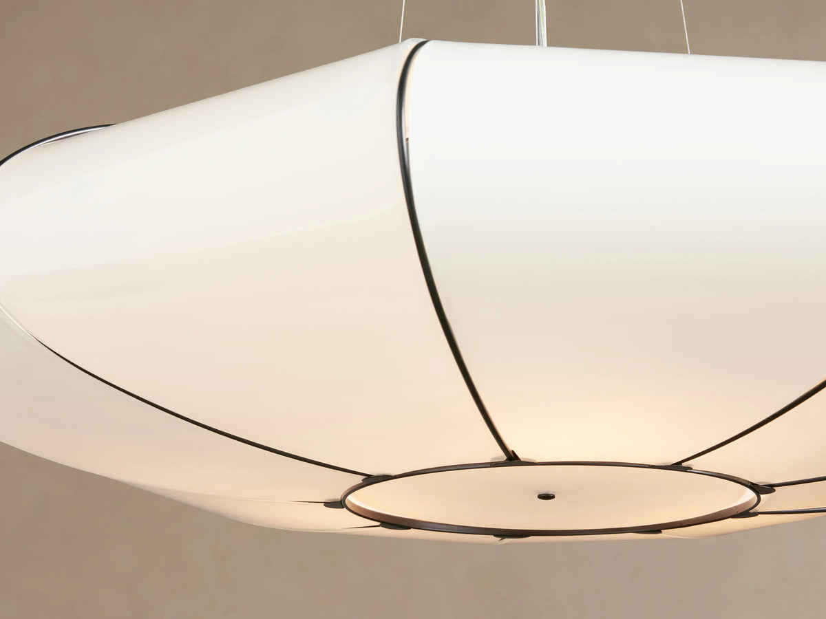 Nuvola Chandelier: Oval white milk glass pendant light with dark bronze-finished steel frame, hanging against a light brown wall.