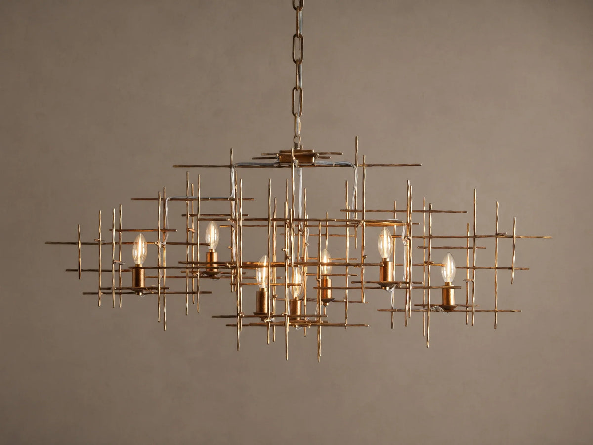 Fritz Chandelier: Hand-hammered antique gold iron rectangular chandelier with an intricate grid design and seven exposed, lit bulbs.