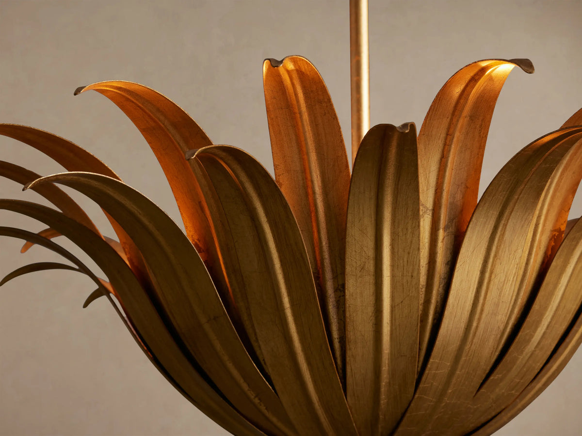 Matilde Pendant: Antique-gold iron floral pendant light, resembling an open bloom with fanned petals, hanging from a chain.