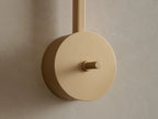 Costella Grand Sconce: Close-up of softly glowing round opal glass diffuser on vertical champagne gold arm.