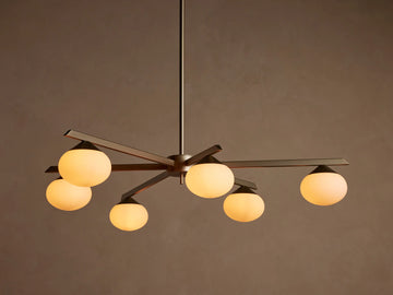 Costella Round Chandelier with six illuminated opal glass globe diffusers on champagne finish iron arms, hanging from above.