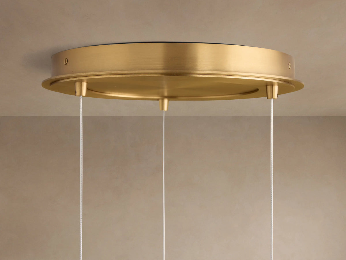 Casen Round Chandelier satin brass ceiling canopy, seen from below, with three thin white suspension cords descending.